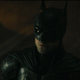 Robert Pattinson as Batman, staring up at the Bat signal.